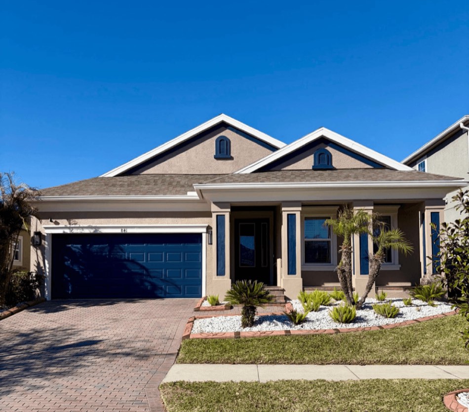 Home after two-tone exterior painting with navy accents, Sarasota FL
